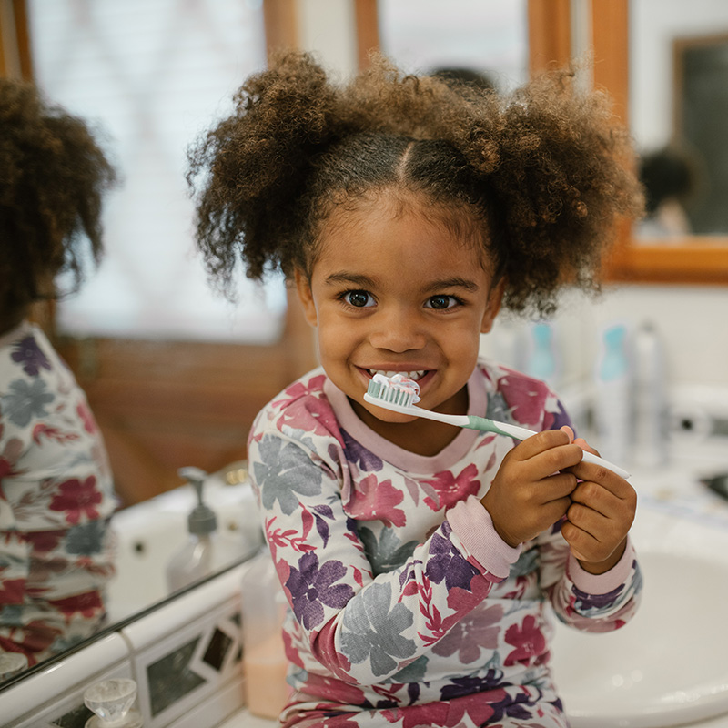 Girl brushing his teeth and smiling